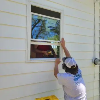 Person installing house window frame